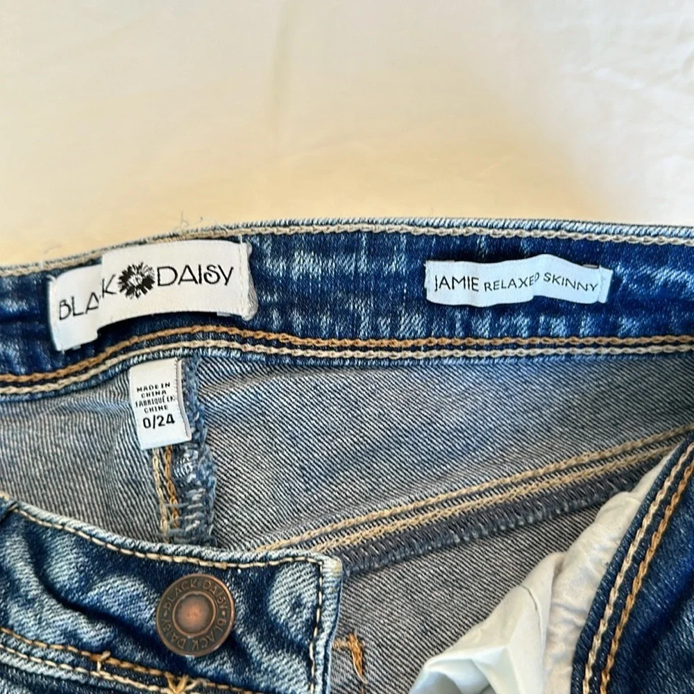 Black Daisy jeans with gem embellishments and rips w/ silver lining 26.5” inseam